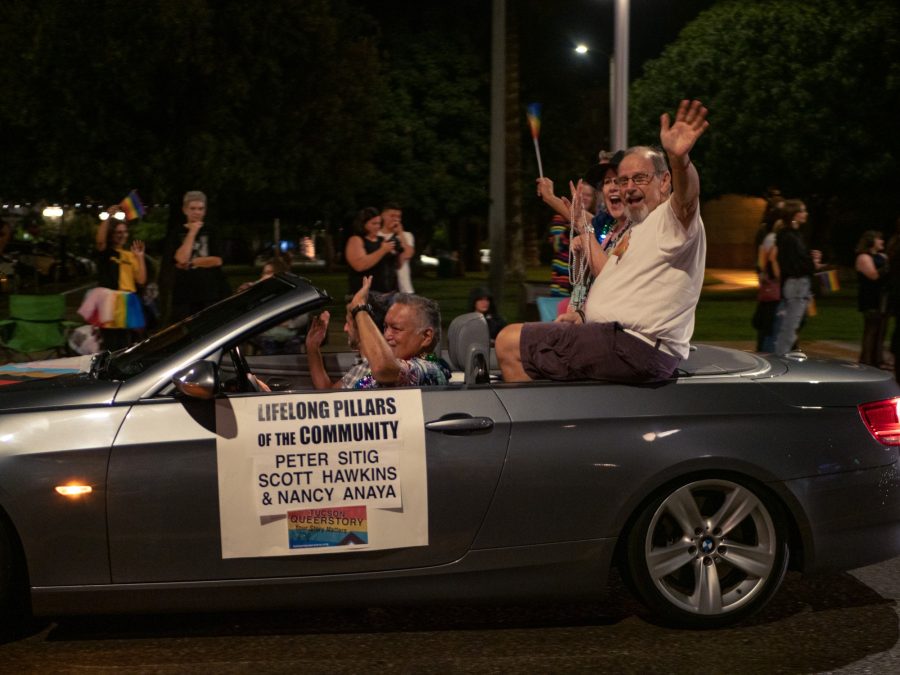 A car driving in the Pride Parade presented by Intuit on the Lifelong Pillars of the Community. They are a part of the Tucson Queerstory section of the parade. 