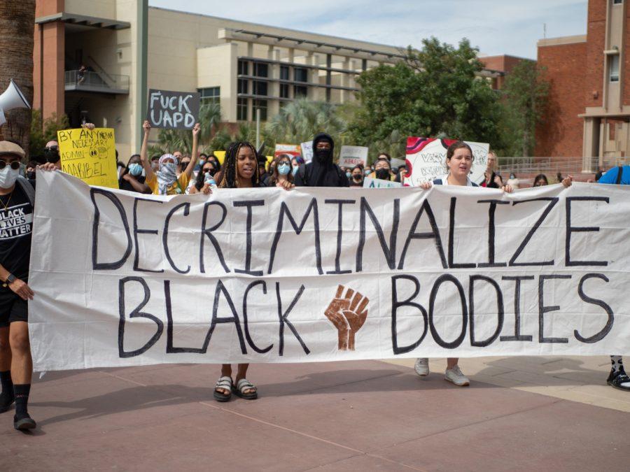 Protestors hold a banner that says Decriminalize Black Bodies at the Decriminalize Black Bodies March and Protest on Friday, Oct. 14, at the University of Arizona. The protest was run by the Coalition of Black Students and Allies.
