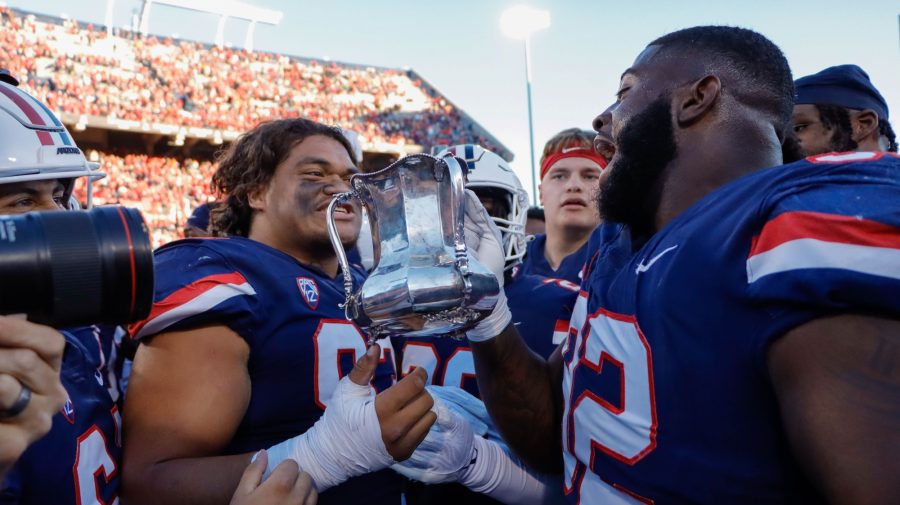 Kyon Barrs a defensive tackle on the Arizona football team holds the Territorial Cup with teammate Jacob Kongaia after winning a game against rival Arizona State University on Nov. 25, in Arizona Stadium. The wildcats won 38-35.