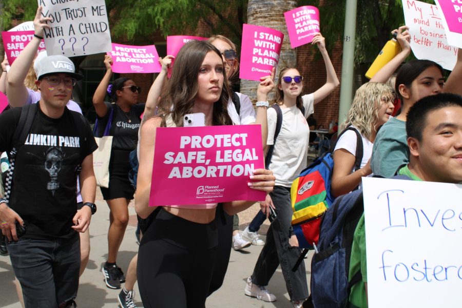A crowd of University of Arizona students and community members march along the middle of campus, holding signs in support of pro-choice on Thursday, April 13 2023. The protest was held to counter the anti-abortion group that set up a demonstration on the UA Mall for two consecutive days displaying large, graphic images of blood and dead people.