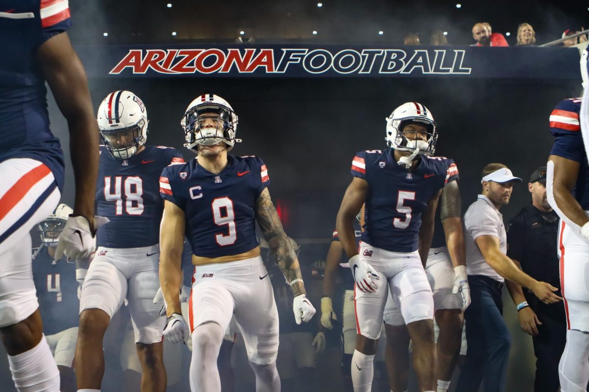 Arizona football safety Gunner Maldonado (9), linebacker Jacob Manu (5) and defensive lineman Orin Patu (48) run out of the tunnel before the game against the University of Texas at El Paso on Saturday, Sept. 16. The Wildcats won 31-10.