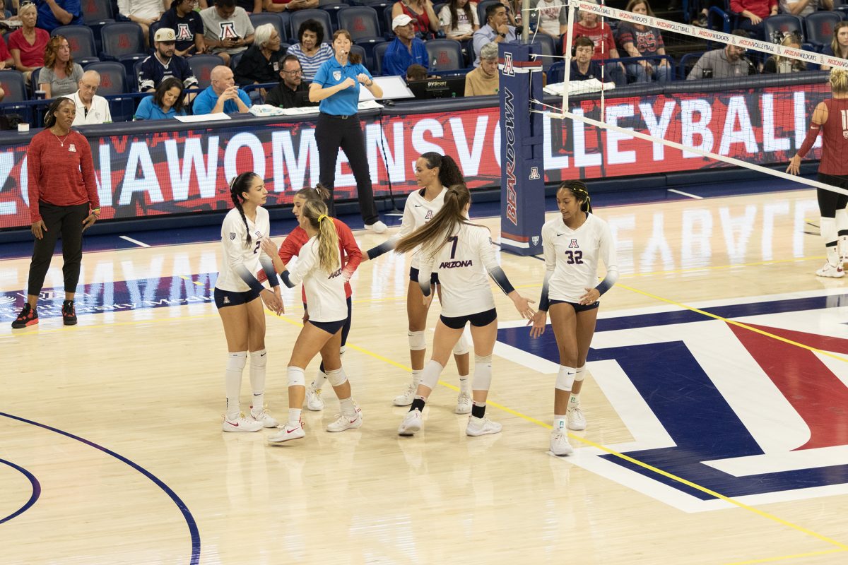 The Arizona volleyball team high fives after Washington scores a point against them during the game on Sept. 24 in McKale Center. The Wildcats went on to lose the game 2-3 sets.