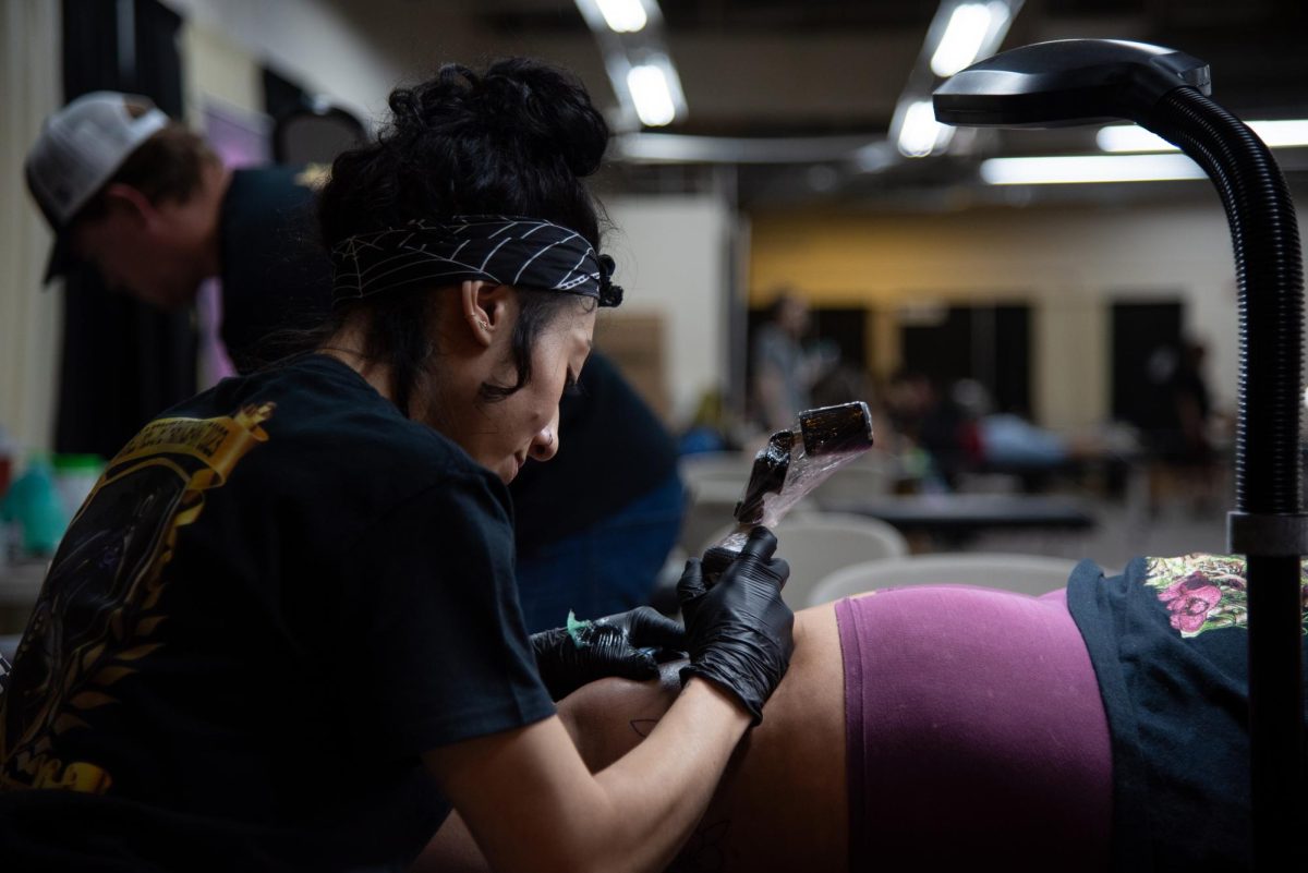 A tattoo artist contributes to the mission established by Spark Project Collective on Oct. 13 at the Tucson Expo Center. Part of the proceeds will be given back to Tucson to facilitate community-driven events.
