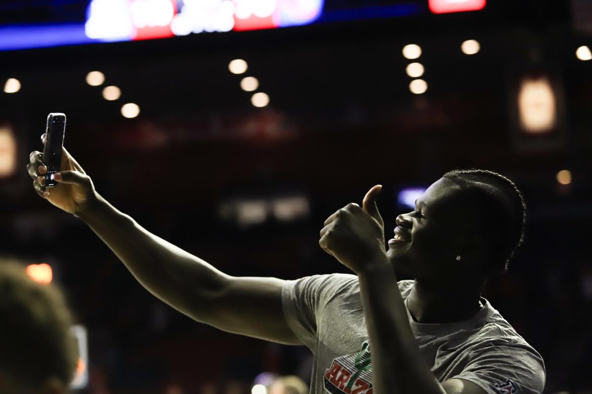 Arizona mens basketball center Oumar Ballo stops to take a selfie with a fan after a win against Lewis-Clark State College in McKale Center on Friday, Oct. 20. Ballo did not play, but is expected to return soon.