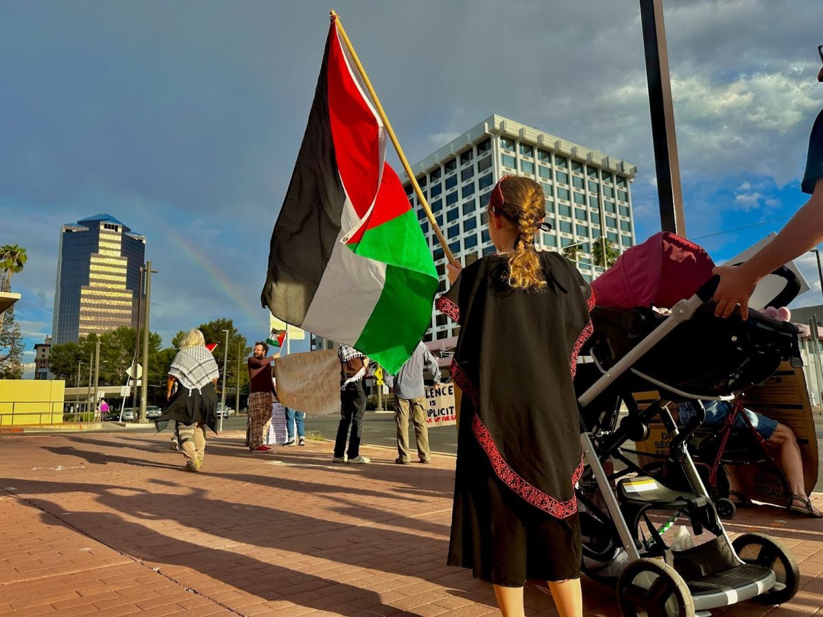 A young girl waves the flag of Palestine with her family outside the downtown Tucson Federal Building, 300 W. Congress St., on Monday, Oct. 9. A group of people rallied there to chant support for Palestine. (Liv Leonard, El Inde Arizona)