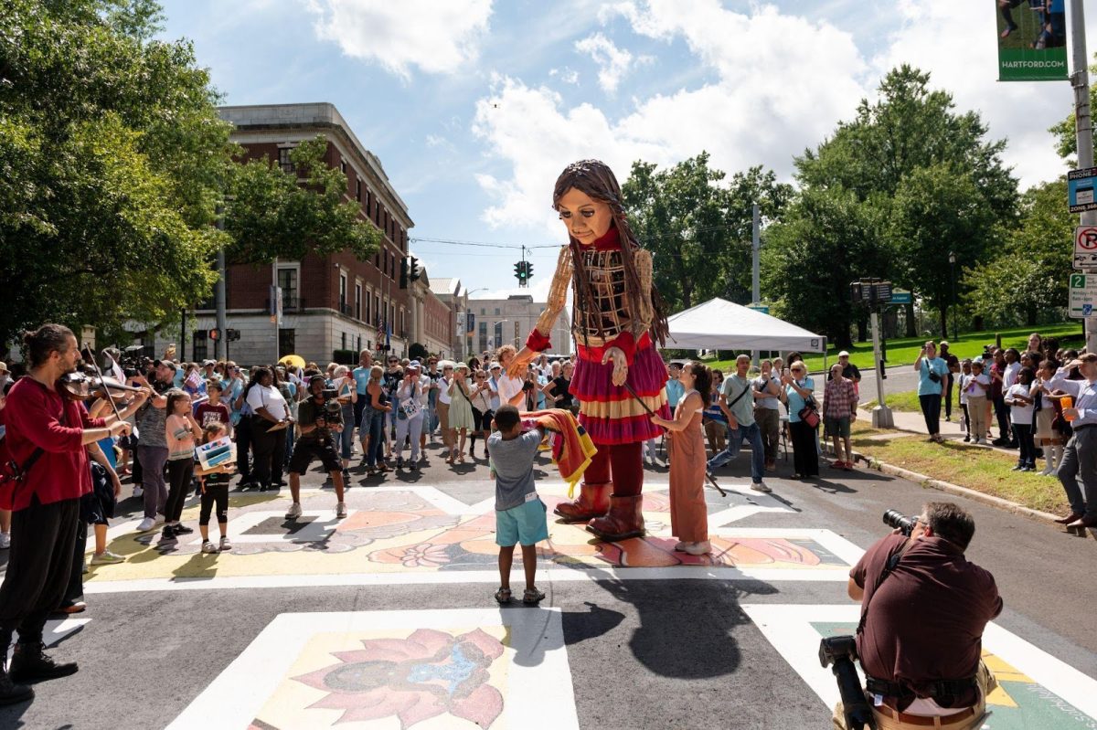 Little Amal plays with children and enjoys music from several local music groups in Hartford, Connecticut. (Photo courtesy of Arizona Arts Live). 