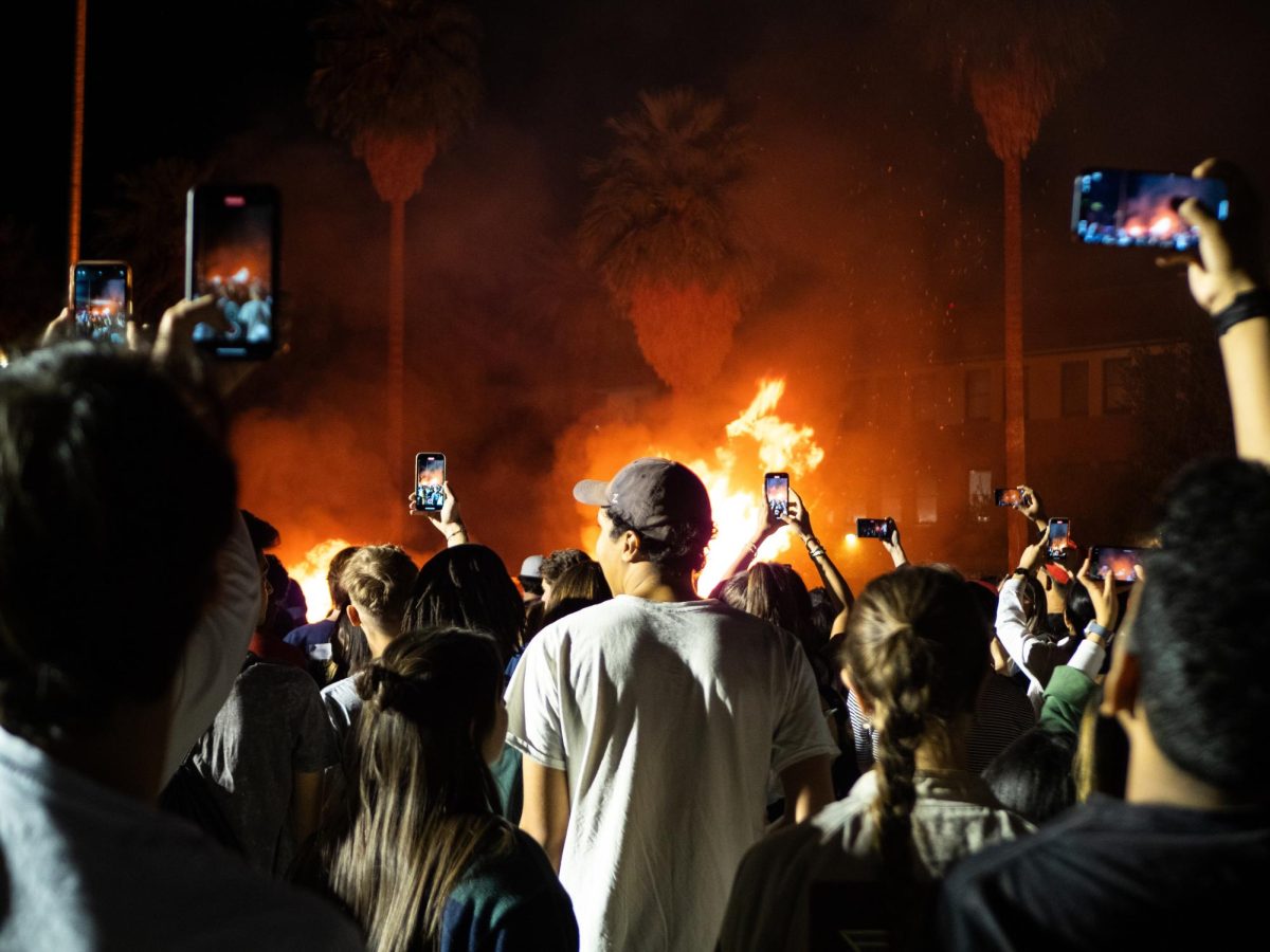The crowd takes photos of the bonfire at the Homecoming Bonfire and Royalty Crowning at 7 p.m. on Nov. 3 on the west side of Old Main. The event anticipated Saturday’s football game against UCLA. 
