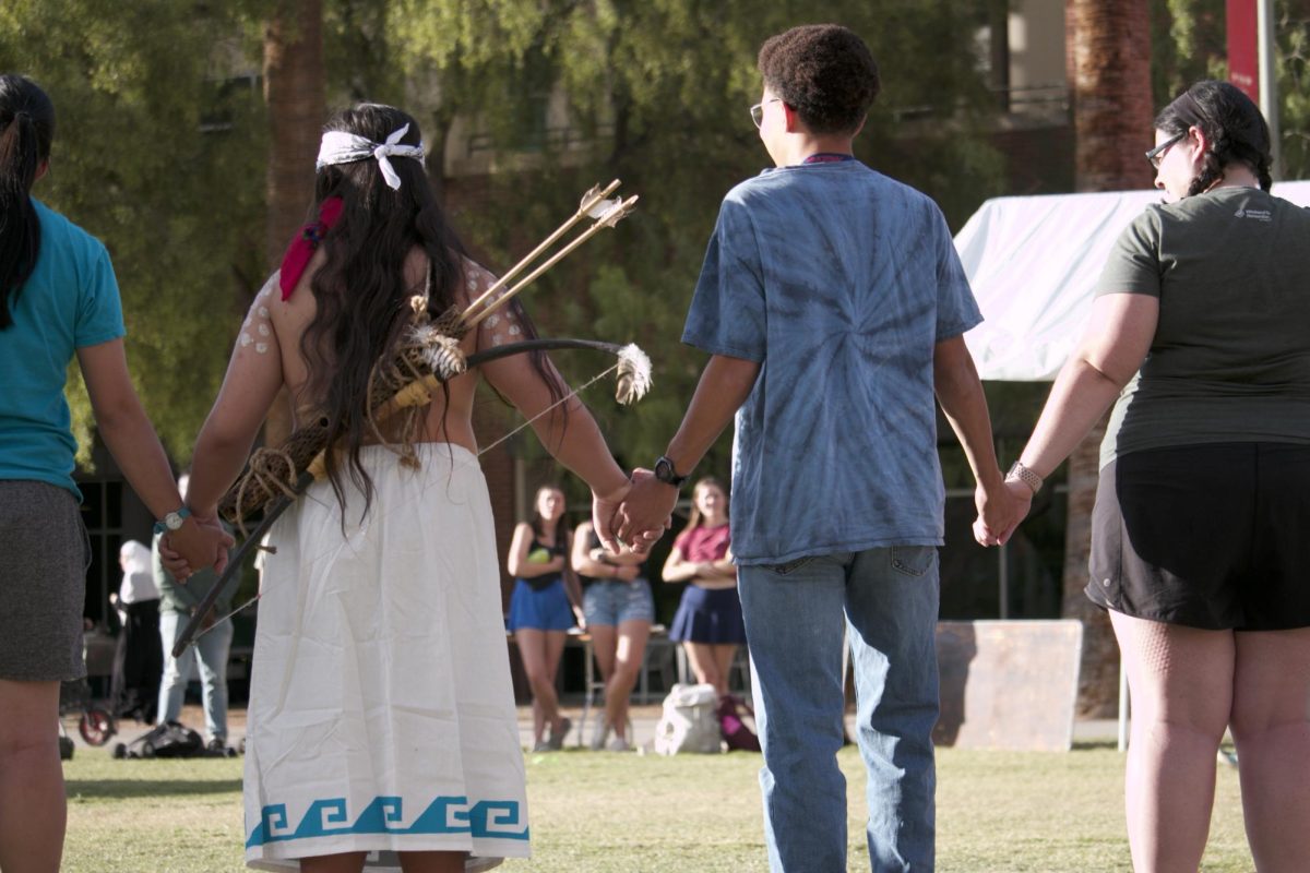People hold hands in preparation to dance at the Indigenous Peoples Day celebration on the UA Mall on Oct. 9. Indigenous Peoples Day recognizes that Native Americans were on this land thousands of years before white settlers.
