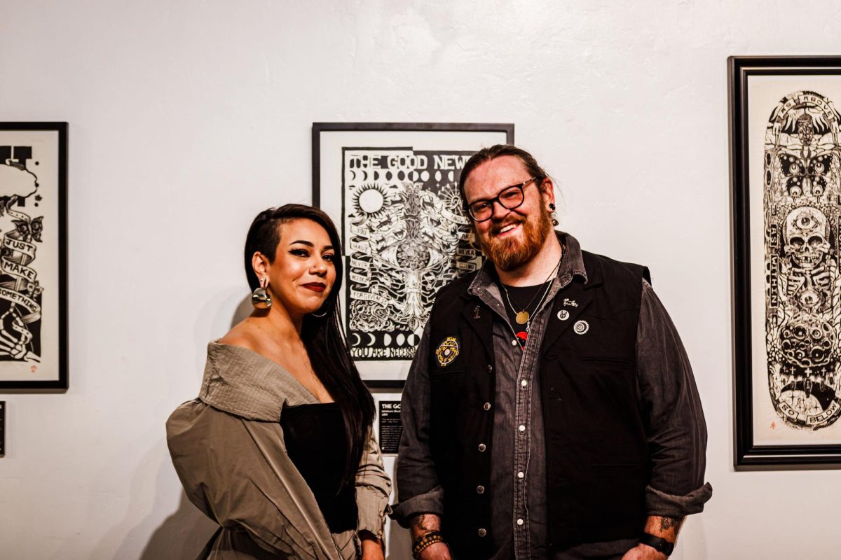 Artist Ben Brockman, also known as  The Sacred Trust, standing with &gallery curator Cynthia Naugle in front of a piece being showcased until Feb. 5. Courtesy of Manic Image.
