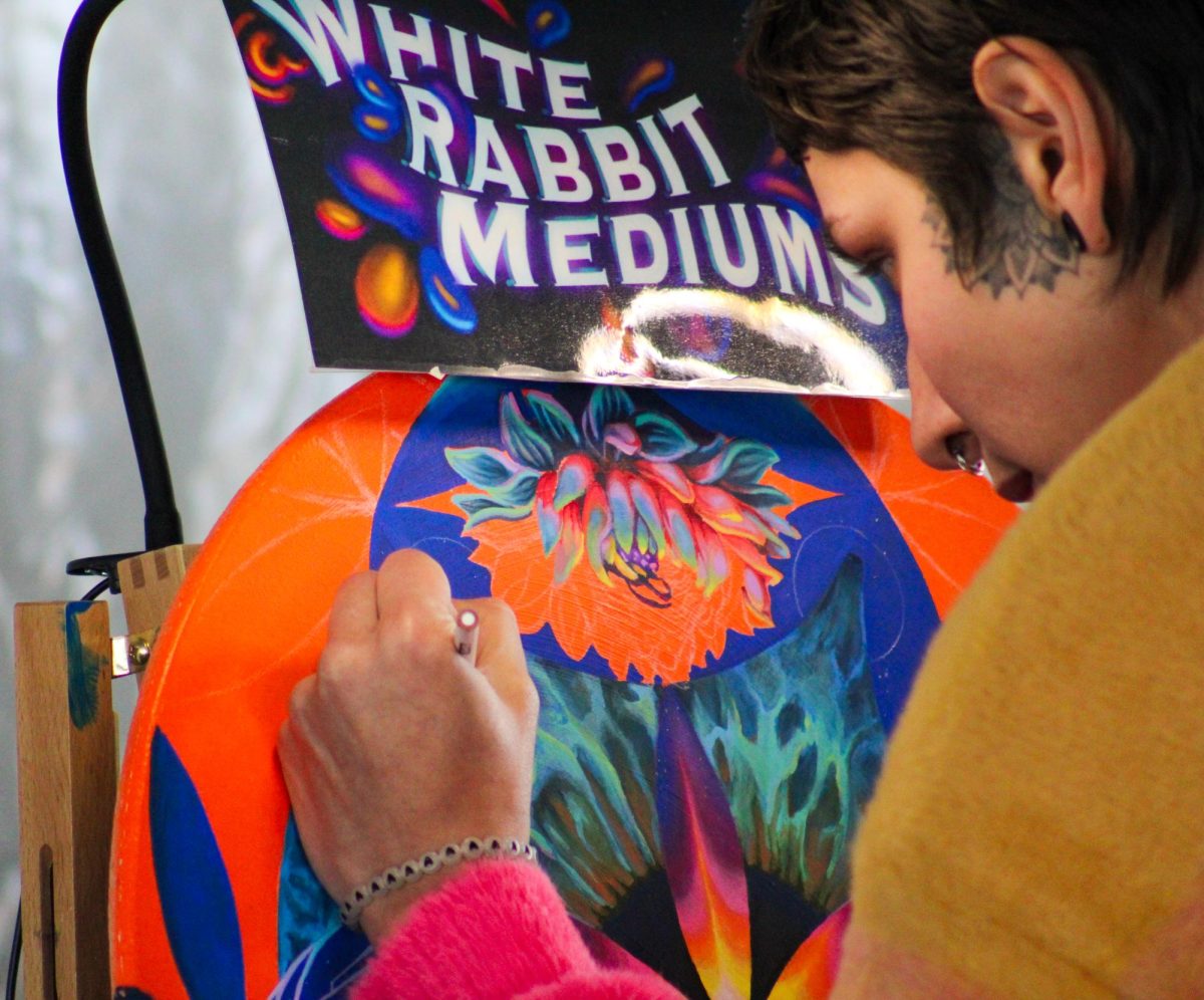 Kelsey Botello of White Rabbit Mediums works on a live painting at the Gem & Jam Festival on Feb. 3. Botello is among many artists who create works of art in front of live festival crowds.
