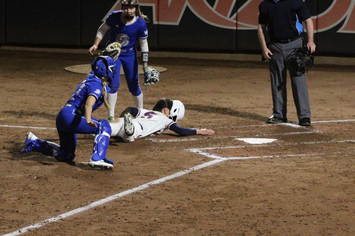 Arizonas Zaedi Tagalog tries to steel home but get out before she makes it at the Hillenbrand Invitational against Drake on Feb. 22. Zaedis helmet comes off as she slides into home.