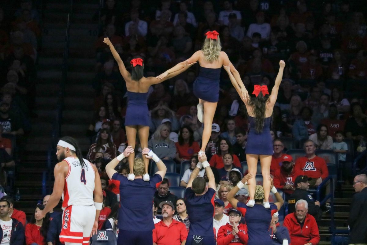 The Arizona cheer team waves to the crowd in McKale Center before the basketball game against Stanford on Feb. 4. Kylan Boswell is pictured awaiting tipoff. 