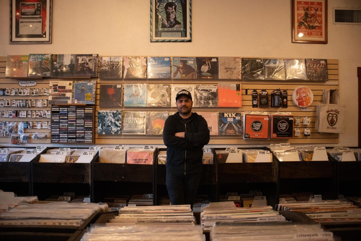 Kellen Fortier, co-owner of Wooden Tooth Records, stands in front of a wall of records on March 25. Wooden Tooth Records has called Tucson home since 2015.