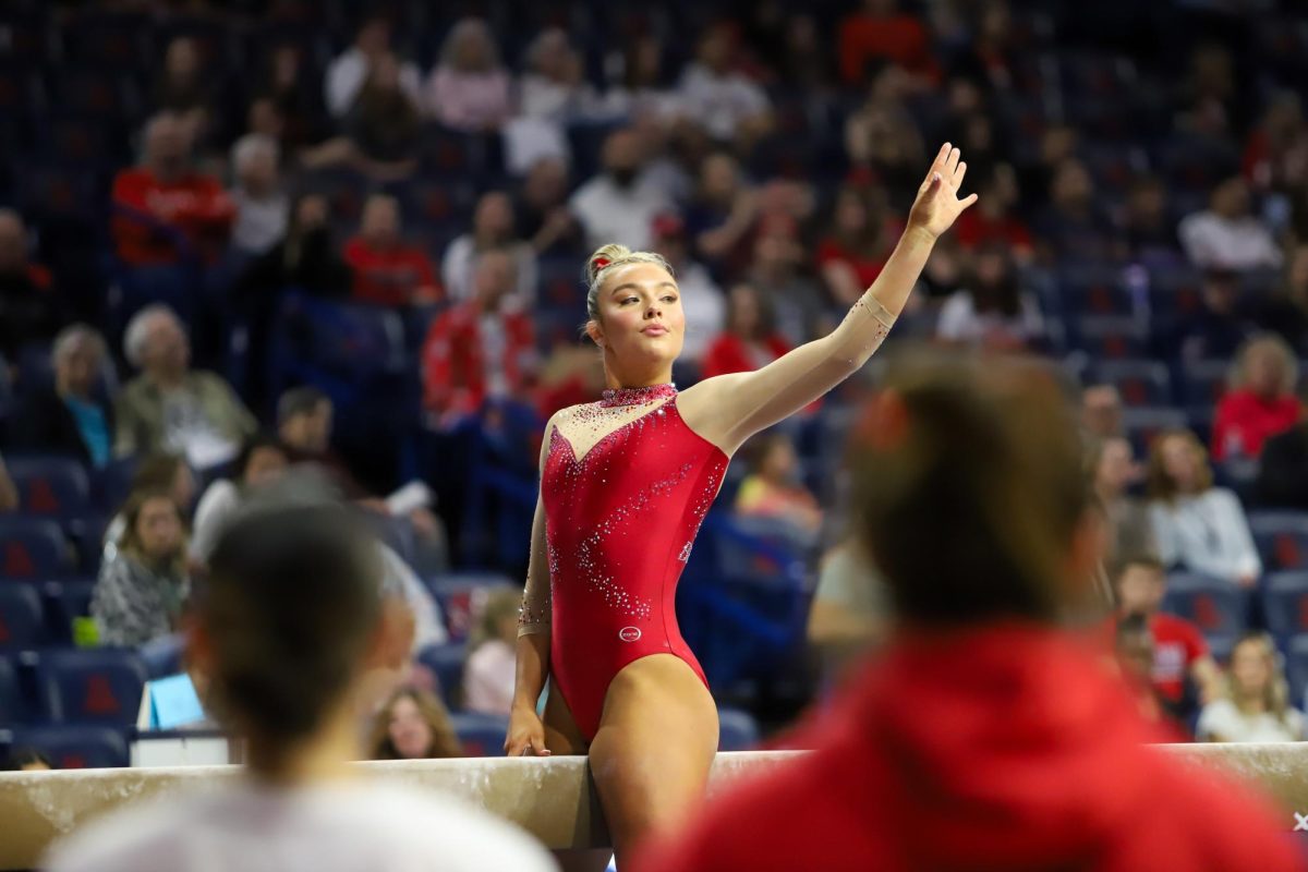 The Arizona GymCats watch as Emma Strom performs her beam routine in McKale Center on March 13. Arizona scored a 196.900 against Southern Connecticut State University. 
