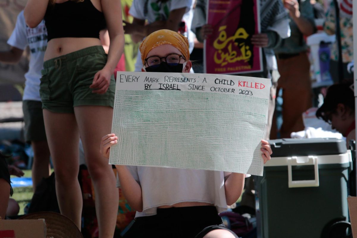 A protester on the University of Arizona Mall holds up a sign tallying the number of children killed by Israel in Gaza since October on April 29. Israel has faced international criticism by human rights groups for their damage in war.
