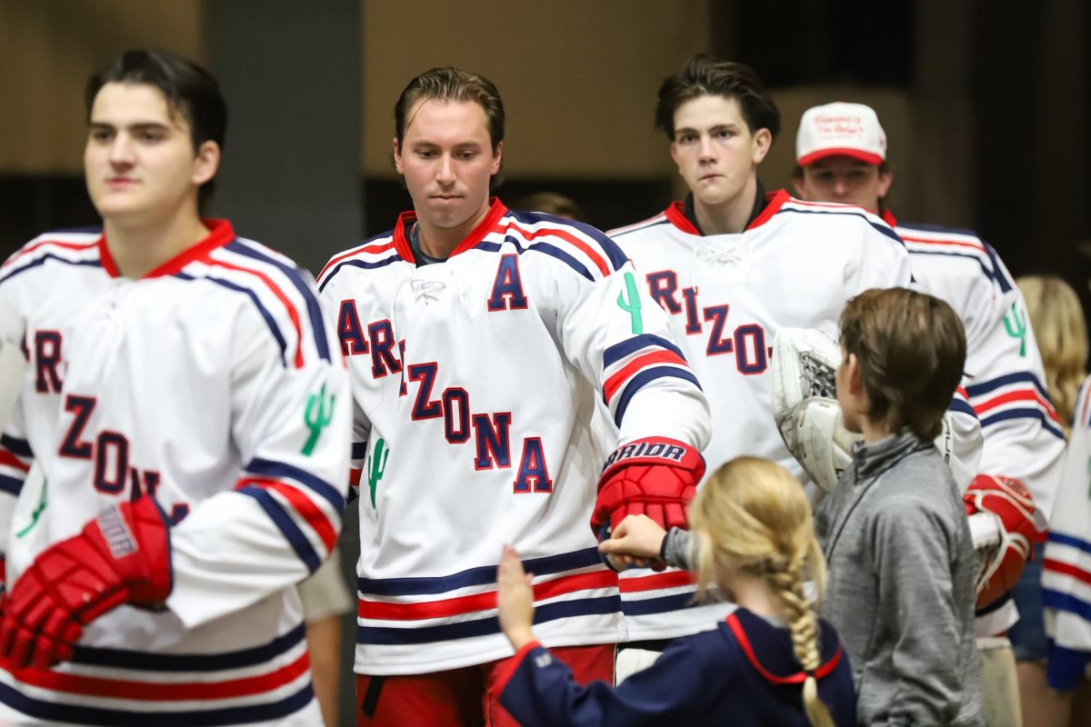 Nicholas Chiocca fist bumps a child walking to the rink in Tucson Convention Center on Sept. 26. Chiocca is a transfer from Hobart College.