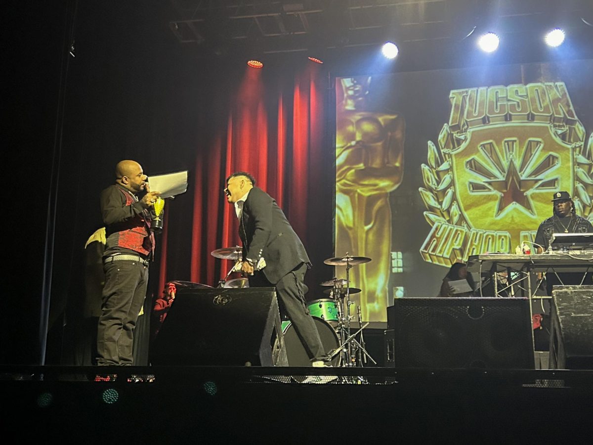 Jahmar Anthony, host of the Tucson Hip-Hop Awards Show, hands Christian Rios a certificate and trophy for winning "Best Hip Hop Dance Instructor" on Sept. 14 at the Rialto Theater. The show featured more than 25 different awards.
