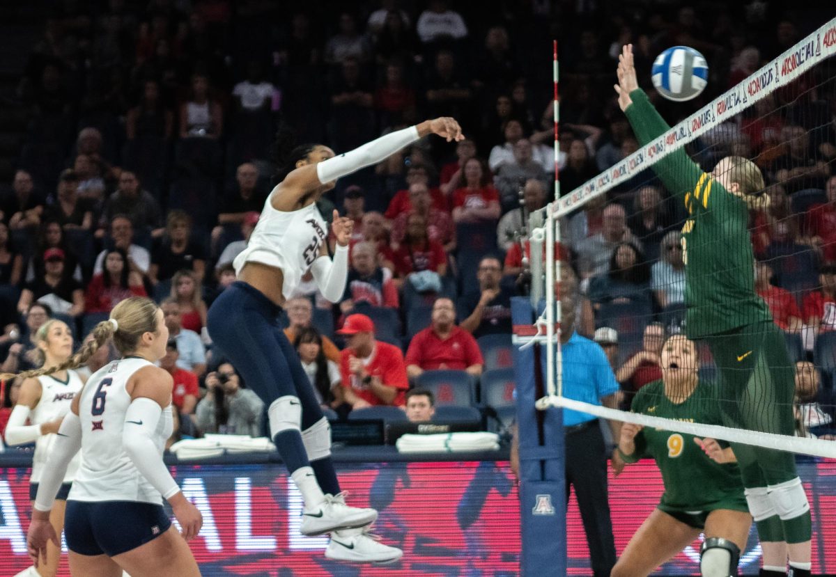 Kiari Robey, 25, on the University of Arizona Women’s Volleyball Team hits the ball past the defenses of North Dakota State in McKale Center on Sept. 19. The Wildcats won the game.