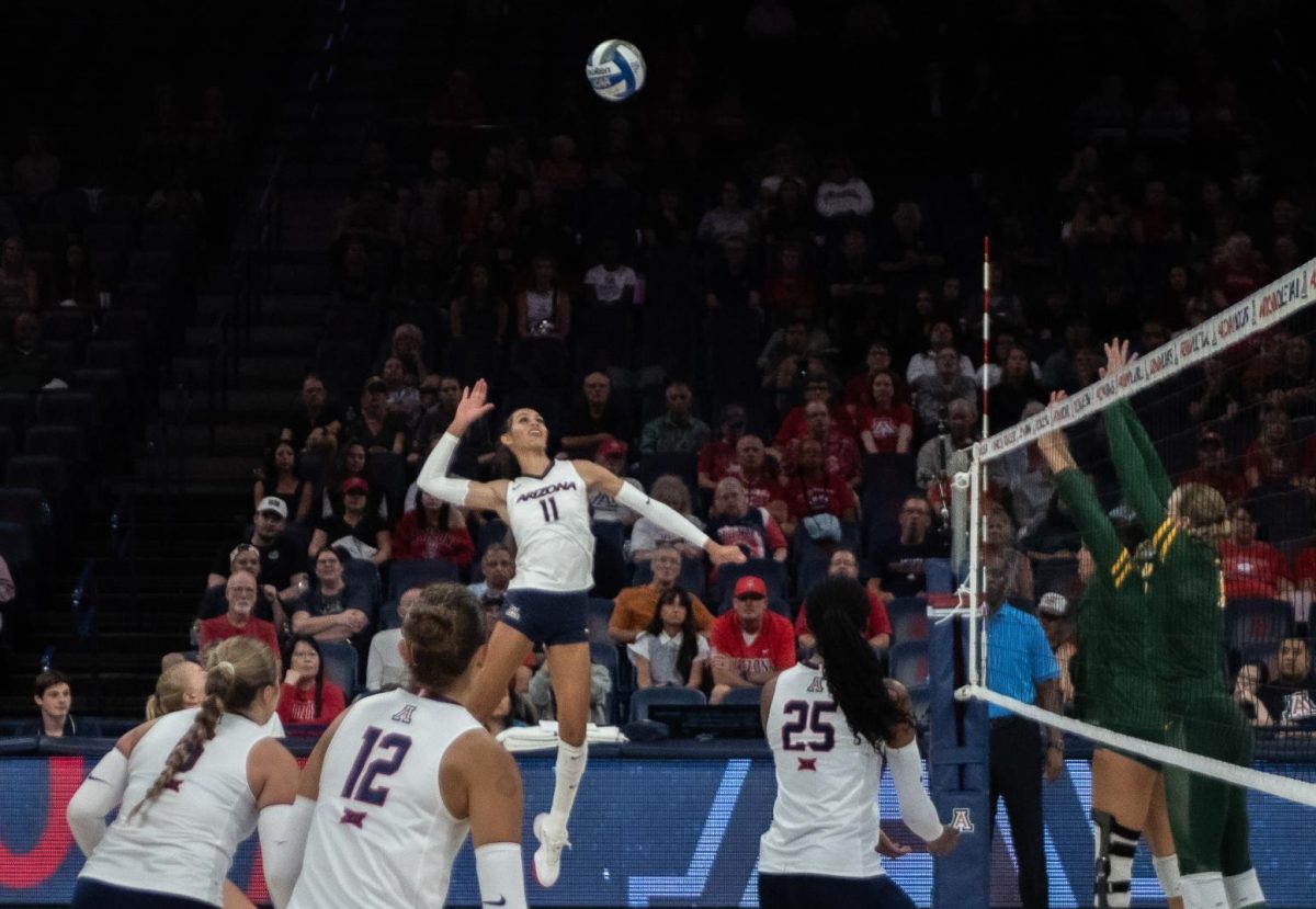 Jaelyn Hodge, 11, jumps up to spike the ball in McKale Center on Sept. 19. Hodge helped lead the Wildcats with 17 kills. 