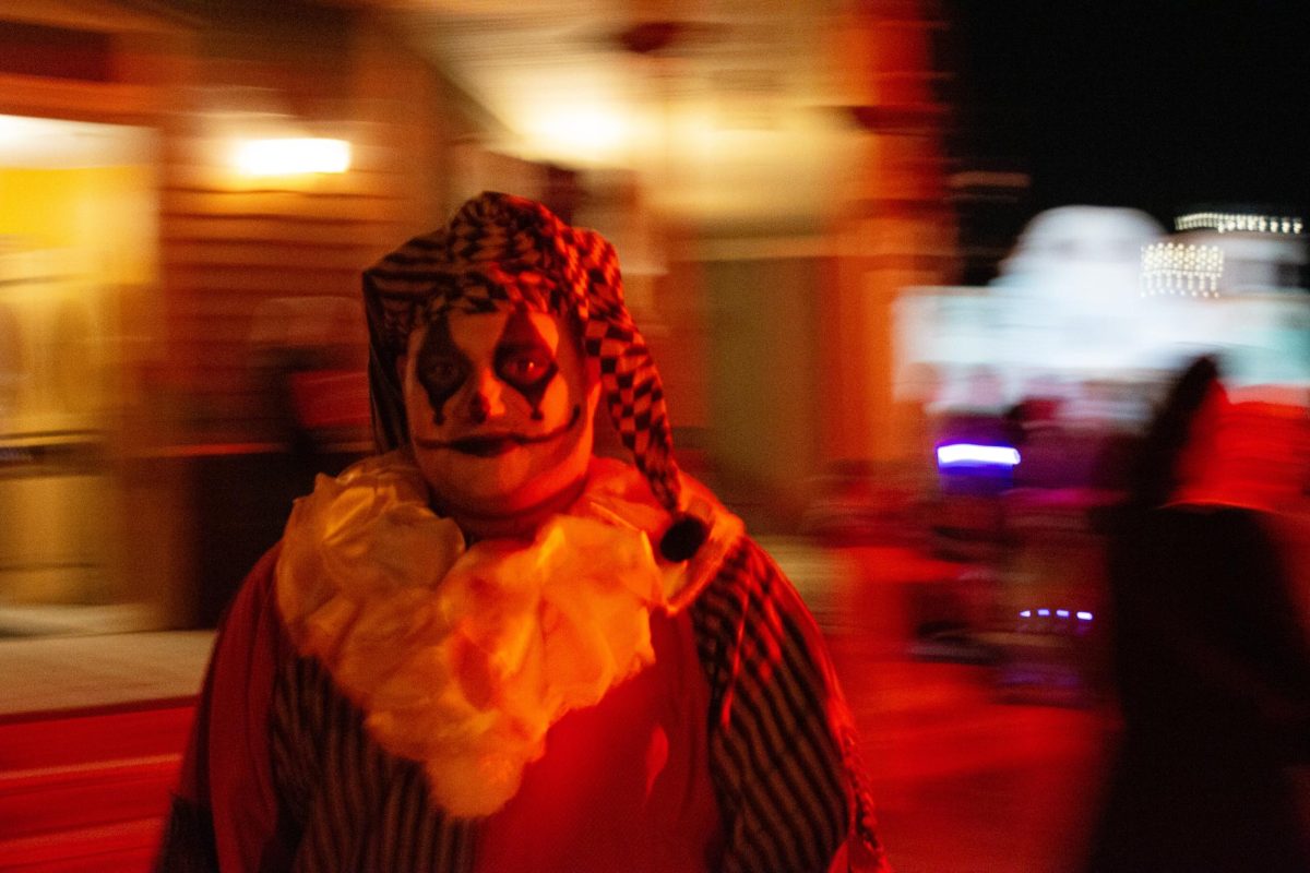 A clown scare actor moves quickly past the Grand Palace on Sept. 28 at Nightfall at Old Tucson. Old Tucson, which hosts a range of holiday events, was built in 1939 by Columbia Pictures as a set for Western films.