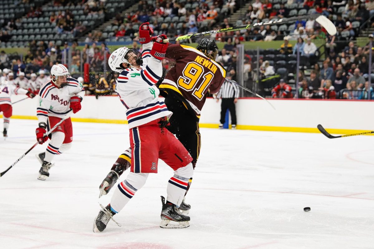 An Arizona forward gets checked by an Arizona State University defender on his way to the goal in Tucson Convention Center on Oct. 4. Hockey was one of five Arizona sports playing at home in the span of the weekend.