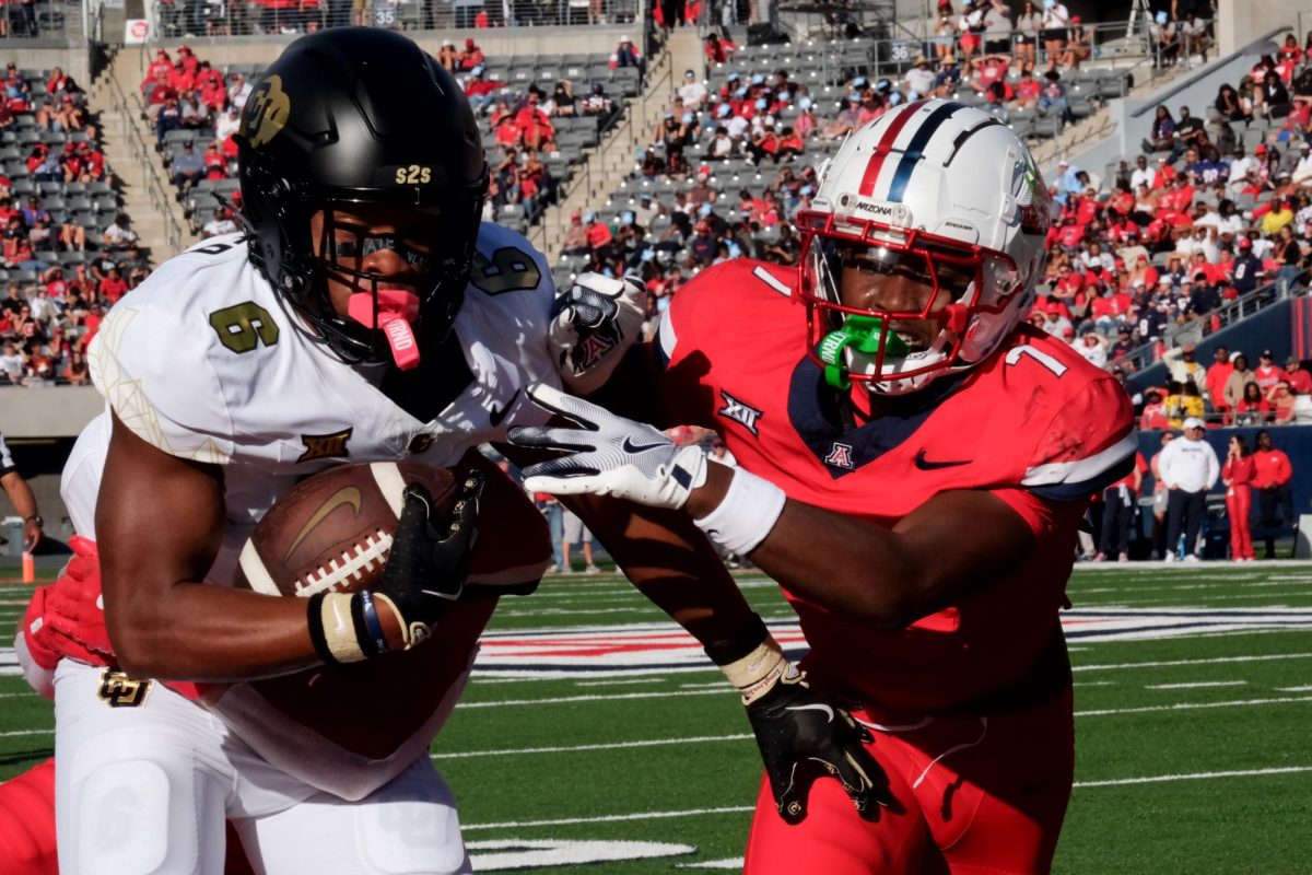 Demetrius Freeney (7) of the Arizona Wildcats grapples Drelon Miller (6) of the Colorado Buffaloes during their game at Arizona Stadium on Oct. 19. The Buffaloes offense blew through the Arizona defense throughout the game.