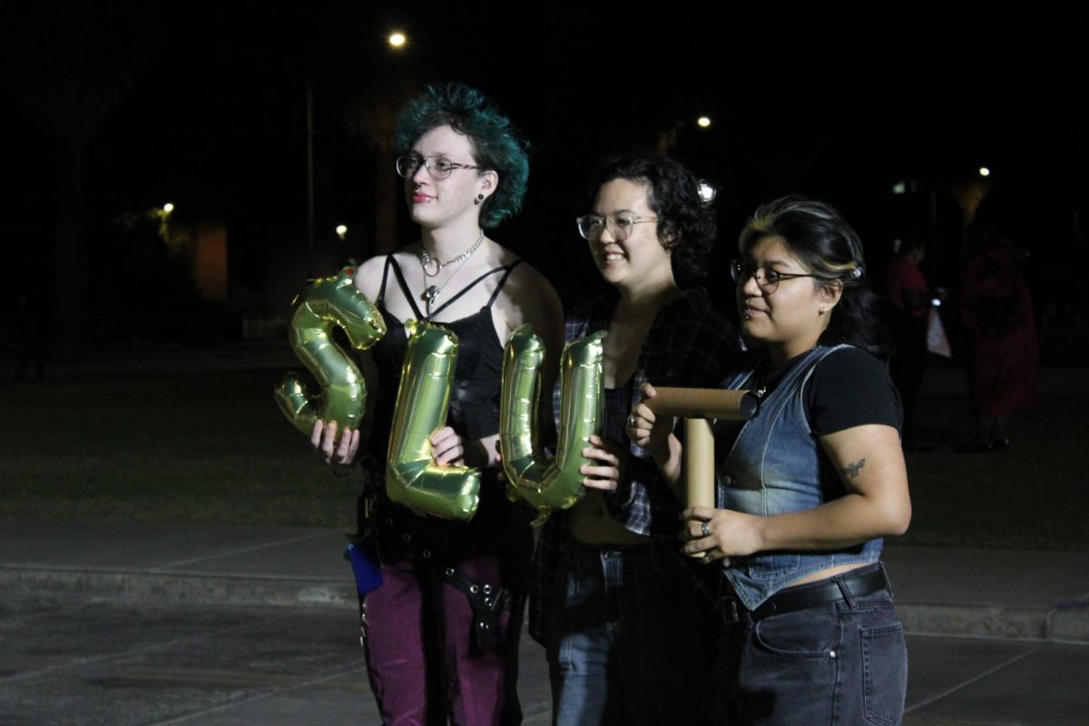 Three people hold up balloons that spell out "SLUT" on Oct. 30 on the UA Mall during the SlutWalk. The movement is to advocate against victim blaming and encouraging self-expression.