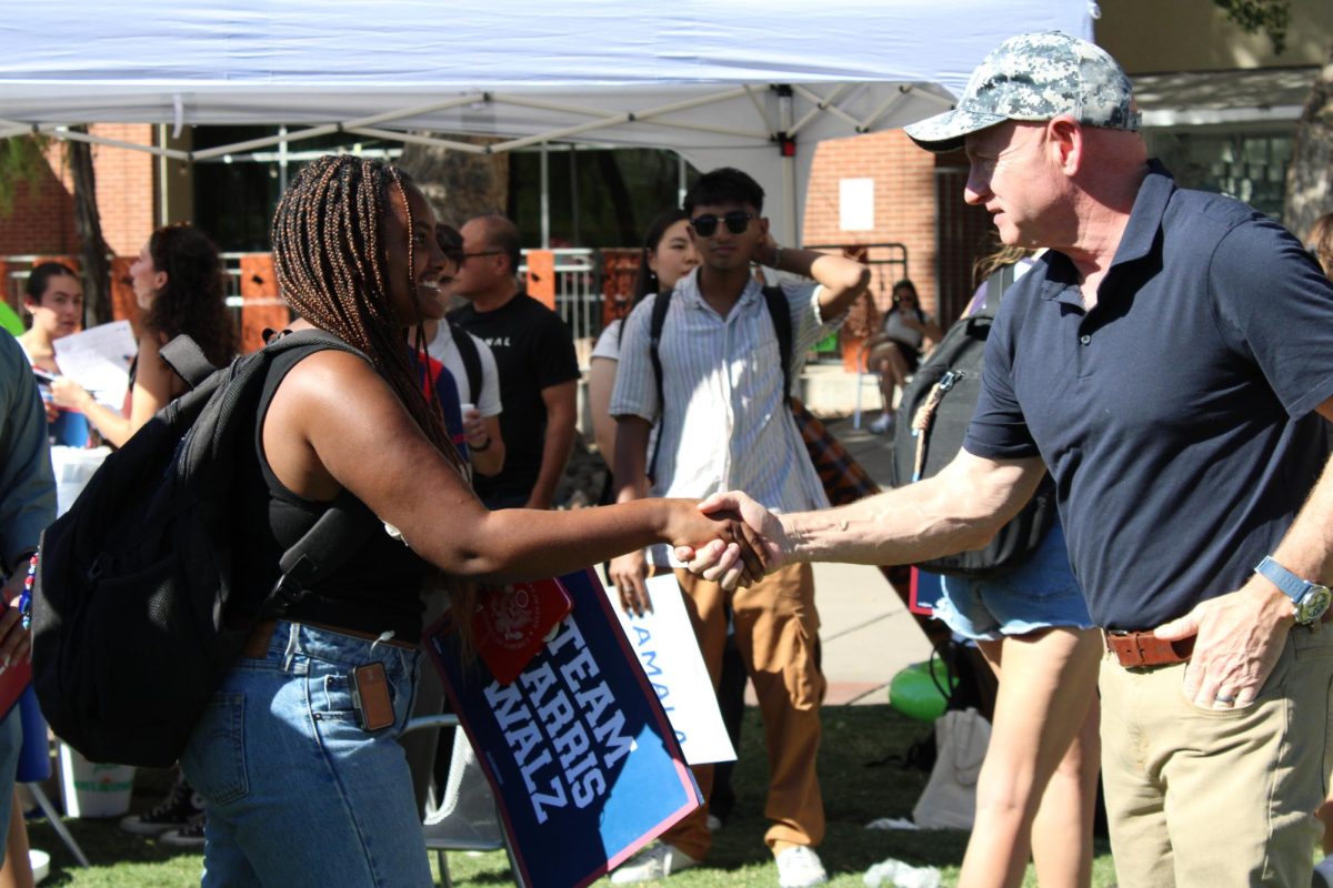 Arizona Senator Mark Kelly shakes a student's hand as they meet on Oct. 15, during a meet and greet on the campus mall. The senator was campaigning for the Harris-Walz campaign.