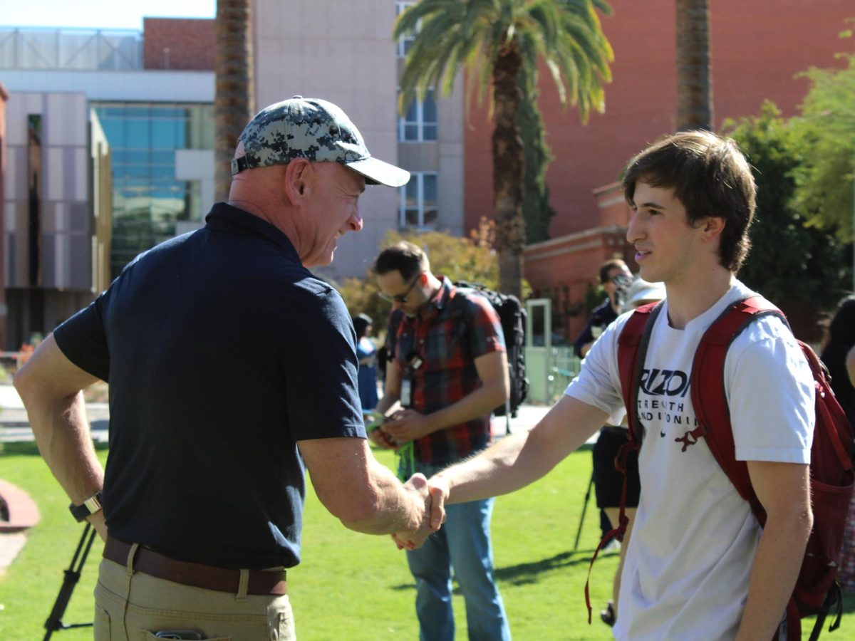 A student shakes U.S. Arizona Senator Mark Kelly's hand on the University of Arizona's campus Mall on Oct. 15. Former ASUA Student Body President Patrick Robles introduced the senator on campus.