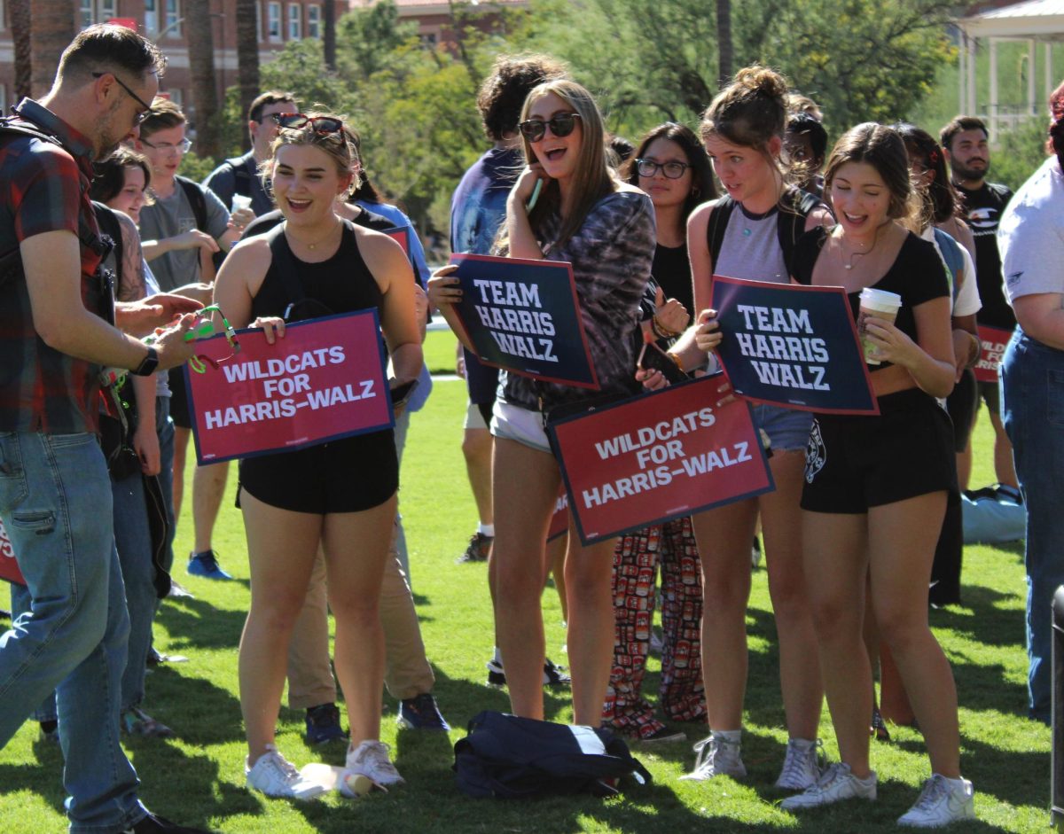 University of Arizona students hold signs for the Harris-Walz campaign on Oct. 15. On the campus Mall signs were giving out and information about upcoming elections.