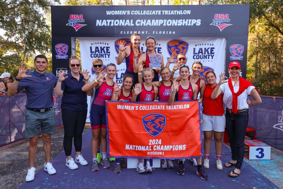 University of Arizona triathlon team stands with its National Championship banner in Clermont Florida. 