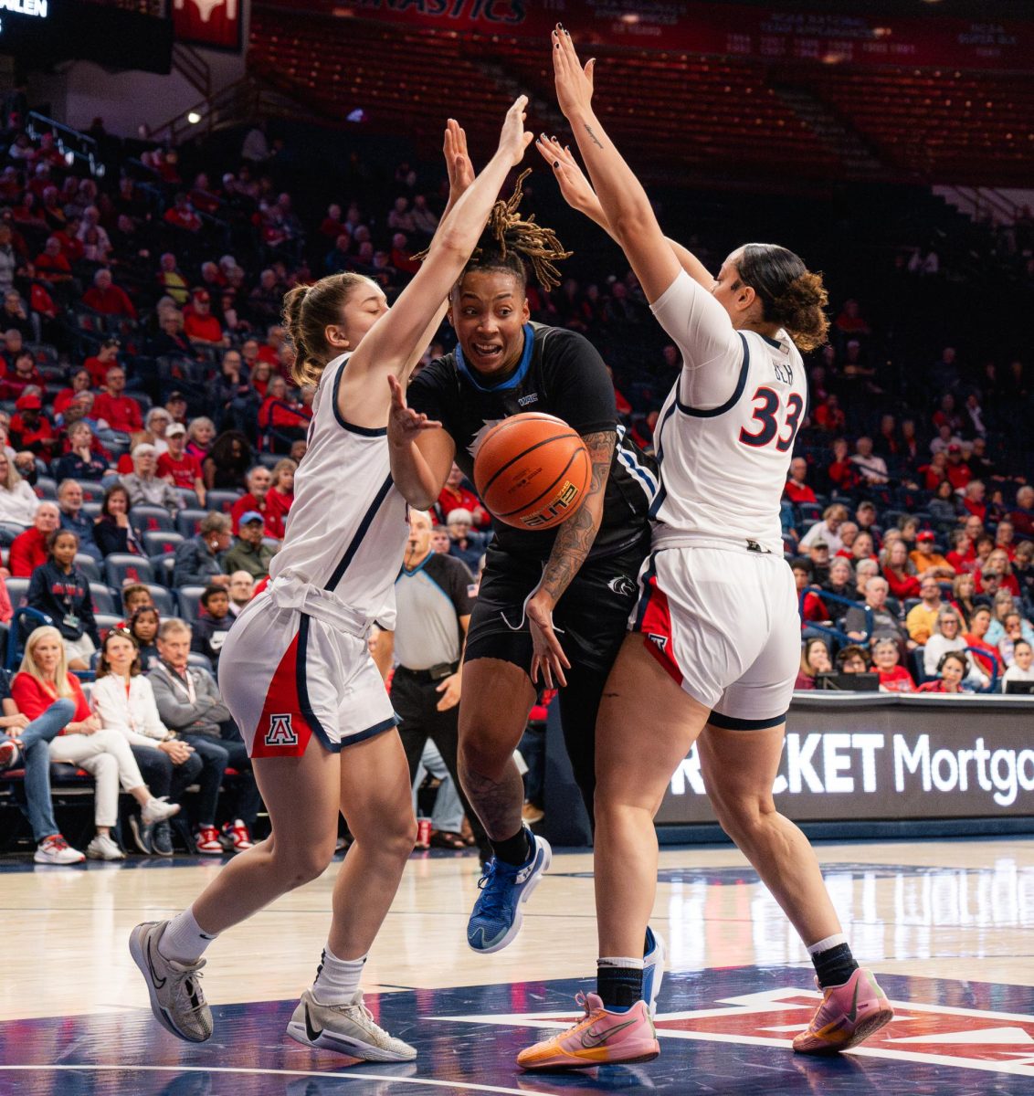 Two players from the University of Arizona block a player from UT Arlington in McKale Center on Nov. 4. The score during halftime was 34-21 with UA leading.