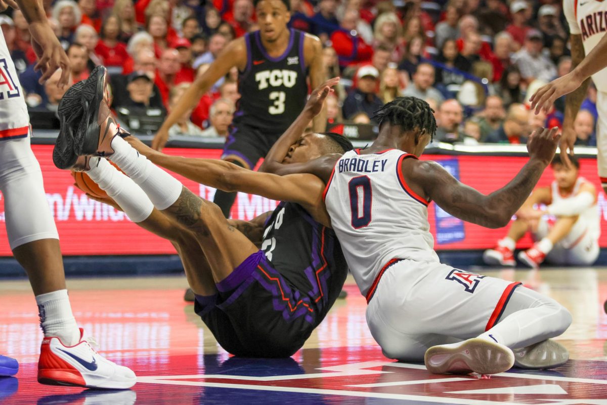 The University of Arizona's Jaden Bradley and Texas Christian University's Vasean Allette fall to the ground in McKale on Dec. 30 at UA's game against TCU. This game marked UA's seventh win of the season, ending with a score of 90-81.