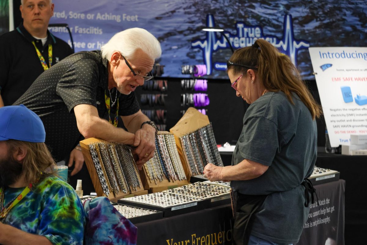 A vendor at the 22nd Street Mineral, Fossil, Gem & Jewelry Show speaks to a potential customer over a table of beads on Feb. 5. The show was originally founded in Denver by Lowell Carhart after he compared the nature of European gem shows to American ones while stationed abroad.