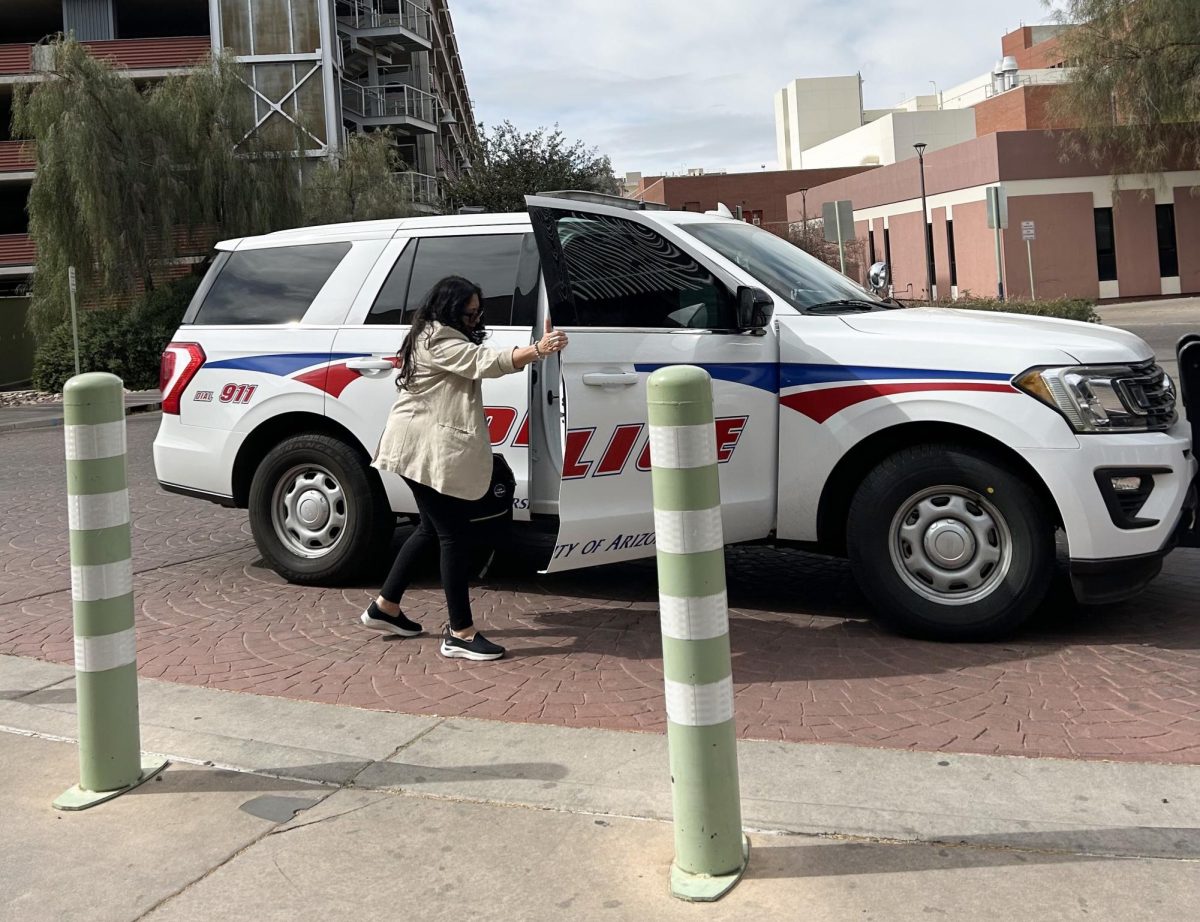 Patti Norris, mental health clinician and liaison to the dean of students leaves a UAPD vehicle following dispatch in front of the University of Arizona Campus Health on Thursday, Feb. 13 in Tucson, Arizona.