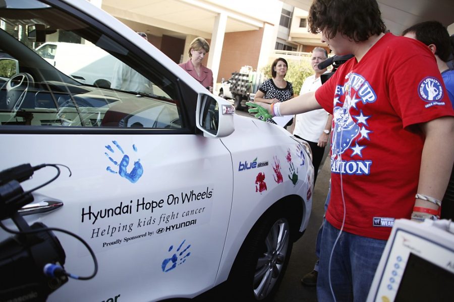 Kevin Brost / Arizona Daily Wildcat

Tyler James Mason, a patient at Diamond Childrens Hospital, imprints his painted hand onto the side of a Hyundai Tucson as part of the Hyundai Hope On Wheels program.