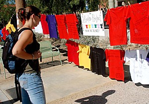 History senior Kara Cooper studies T-shirts that were part of the Clothesline Project outside the Student Union Memorial Center yesterday. The project featured colored T-shirts that represented different kinds of abuse.