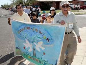 Rahim Raina, right, founder of the Muslim Jewish PeaceWalk, carries the banner alongside Mohamed El-Sharkawy, a board member on the Council of Islamic Arizona, at the Sixth Annual Muslim-Jewish PeaceWalk yesterday afternoon. Supporters gathered at the Islamic Center of Tucson and marched north on Mountain Avenue to East Fort Lowell Road to the Ner Tamid Synagogue. 