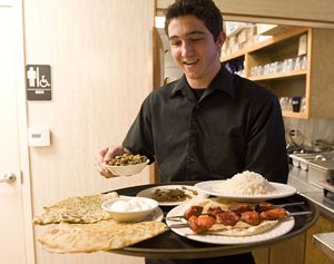 Joe Krause, a first-year student at Pima Community College, prepares to serve dinner to Sultan Palace patrons. 