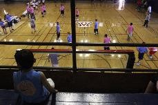 Eli Mendoza, 7, watches one of the games at the ASUA Youth Basketball & Cheer League at Bear Down Gym, Saturday afternoon. UA students coach local youth in basketball and cheerleading in hopes of introducing them to the college atmosphere.