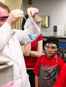 Aaron Zaragosa, a fourth grader at Ignacio Conchos Elementary in south Phoenix, watches Zach Scott, a chemistry graduate student, create a bag of slime out of a mixture of glue, borax, and food coloring as part of a chemistry demonstration during a campus tour put on for the fourth grade class. 