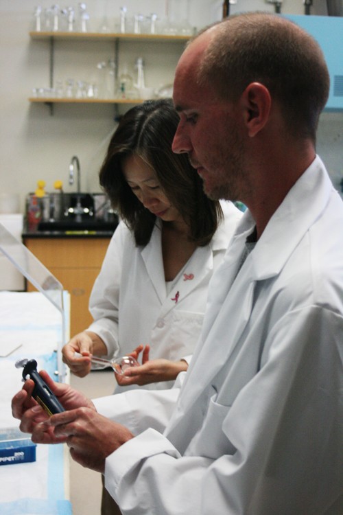 Dr. Sherry Chow, PH.D., the research associate professor who is in charge of the study, and Wade Chew, a research specialist for the green tea study, notice a spec of dirt in a vial that must be completely clean for use with specific chemical samples.