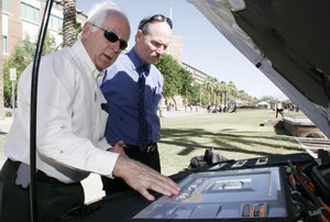 Byron McCormick, left, executive director of fuel cell activities with General Motors, shows engineering dean Tom Peterson the construction of the hydrogen fuel cell underneath the hood of one of GMs new hybrid vehicles on Monday on the UA Mall. 