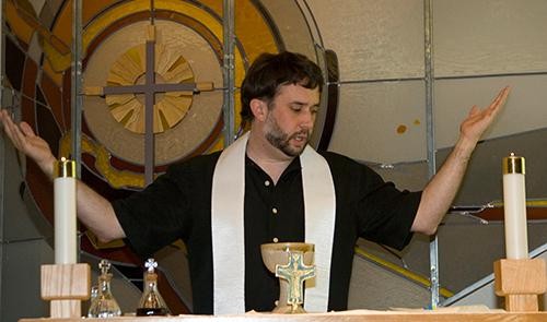 The Rev. Lucas  John, Ph.D., a religion studies professor, performs communion Sunday at 715 N. Park Ave. After the Episcopal Campus Ministries service, Lucas and those in attendance share dinner.
