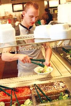 Cole Wellendorf, a media arts senior, builds a salad at Cactus Grill in the Student Union Memorial Center. 