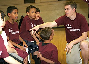 Microbiology freshman Wes Anderson, right, a volunteer coach, gives a halftime pep talk to Taylor Thompson, Austin Borquez, Chris Thompson and Isaiah McKay. The team of fourth- and fifth-graders participated in the Associated Students of the University of Arizona youth basketball league tournament in Bear Down Gymnasium.
