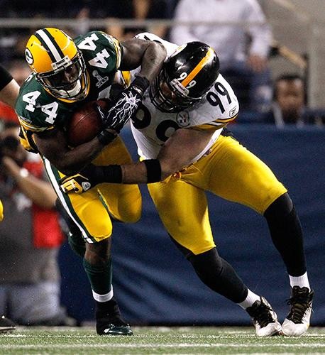 Green Bay Packers running back James Starks (44) brings down Pittsburgh Steelers defensive end Brett Keisel (99) during third quarter action in Super Bowl XLV where the Green Bay Packers face the Pittsburgh Steelers at Cowboys Stadium in Arlington, Texas, Sunday, February 6, 2011. 