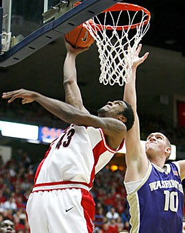 Arizona freshman forward Jordan Hill goes for a reverse layup over Washingtons Spencer Hawes during the second half of the Wildcats 84-54 victory against Washington Saturday in McKale Center.
