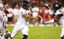 UA quarterback Willie Tuitama, left, hands the ball off to running back Nic Grigsby during Saturdays 36-28 loss to New  Mexico in Albuquerque, N.M. Tuitama will take on UCLA this Saturday in Los Angeles for Arizonas Pac-10 opener.