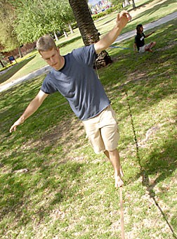 Math and material sciences engineering junior Mark Lauer balances himself while slacklining on Friday. Lauer, a member of the UA Cliffhangers, described slacklining as a relaxing but challenging hobby.